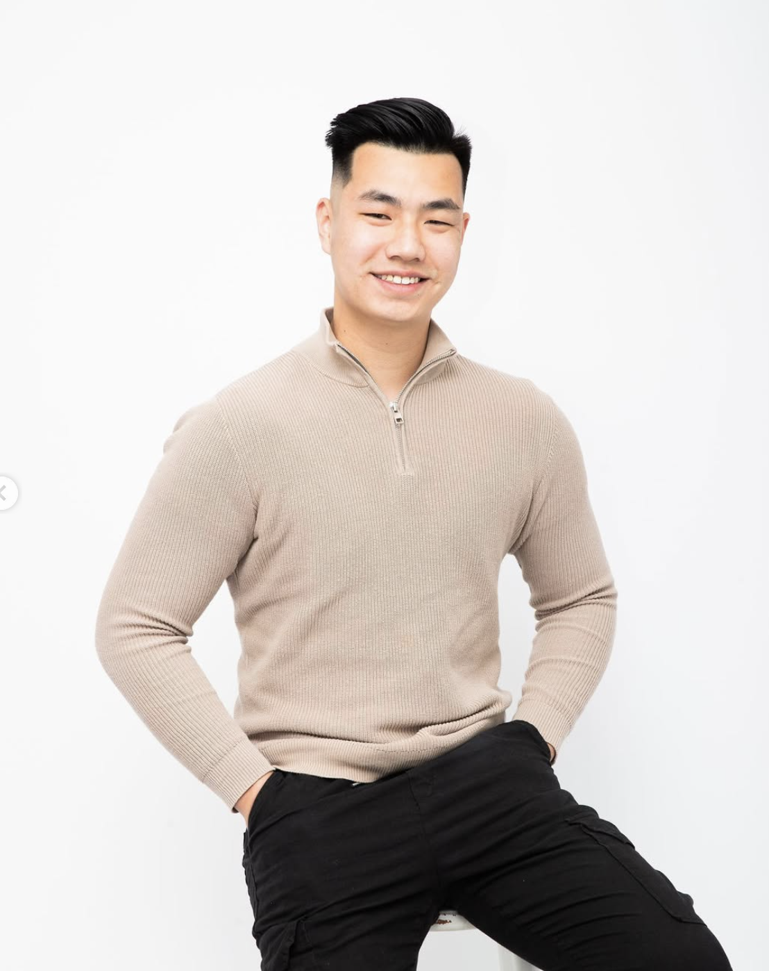 Aaron, founder of Amotion Studios, in a beige knit sweater against a white studio backdrop