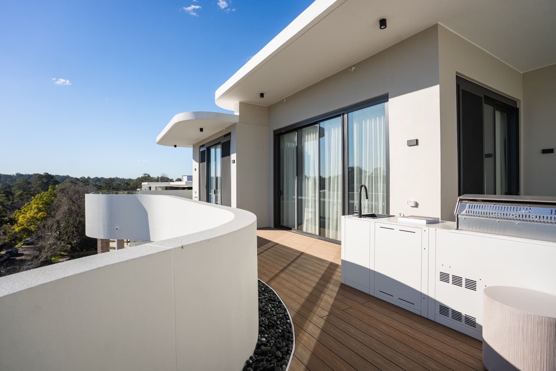 Rooftop terrace with composite decking, outdoor kitchen and curved rendered balustrade